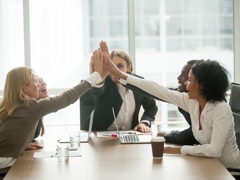Sales team celebrating with a group high-five